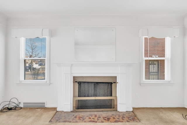 room details featuring visible vents, baseboards, carpet, and a fireplace