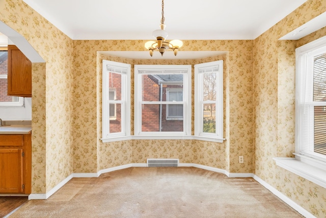 empty room with light carpet, visible vents, wallpapered walls, and baseboards