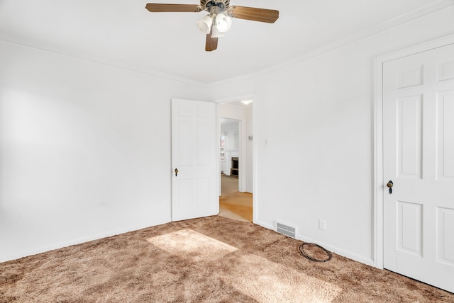 unfurnished bedroom with visible vents, carpet flooring, crown molding, baseboards, and ceiling fan