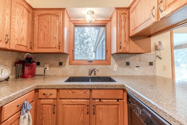 kitchen with a sink, backsplash, dishwasher, and light countertops