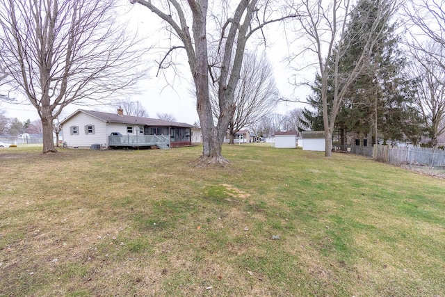 view of yard with central AC unit, a deck, and fence