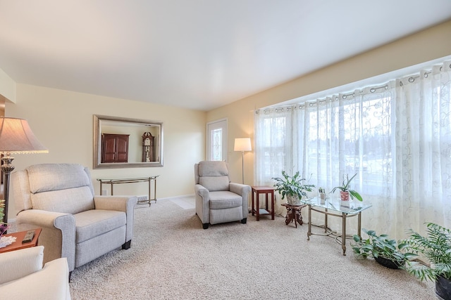 living area with baseboards and carpet