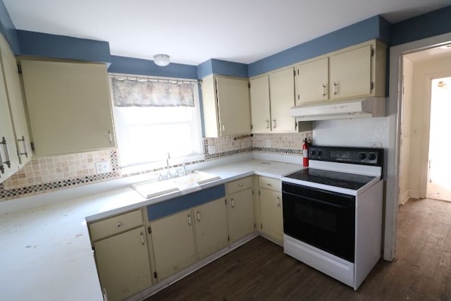 kitchen with under cabinet range hood, tasteful backsplash, light countertops, and electric stove