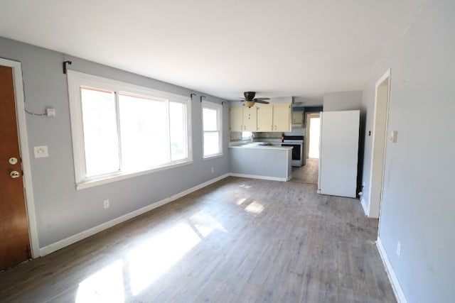 unfurnished living room featuring baseboards, light wood-style floors, and a ceiling fan