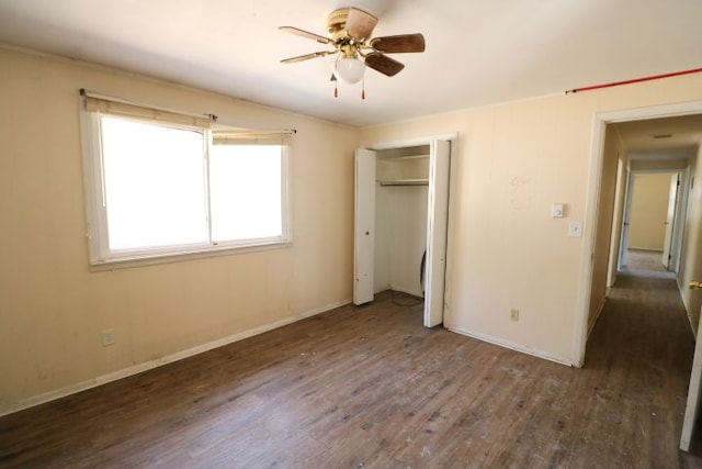 unfurnished bedroom with ceiling fan, wood finished floors, a closet, and baseboards