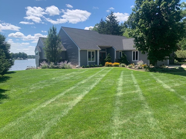 single story home featuring a front lawn and a water view