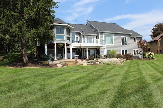 rear view of property featuring a patio, a wooden deck, and a yard