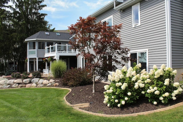 back of house featuring a lawn and a sunroom