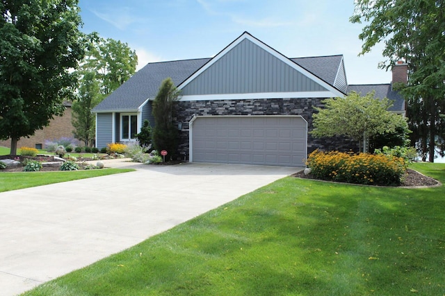 view of front facade featuring a garage, concrete driveway, a front yard, and stone siding