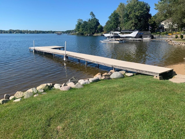 view of dock featuring a water view and a lawn