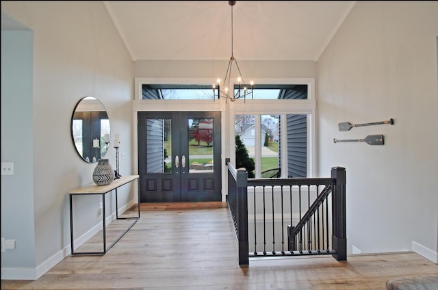 foyer featuring a notable chandelier, lofted ceiling, and wood finished floors