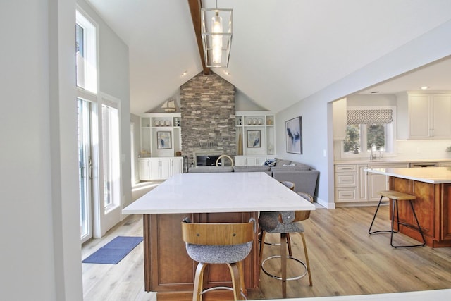 kitchen with open floor plan, a breakfast bar area, light countertops, and light wood-style floors