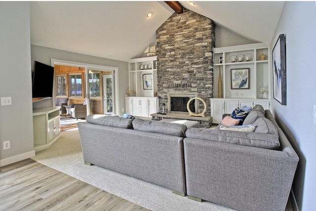 living area with wood finished floors, baseboards, high vaulted ceiling, a stone fireplace, and beamed ceiling