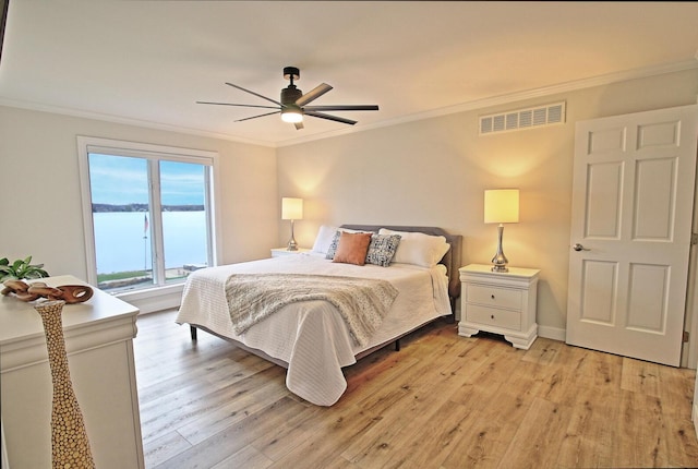 bedroom with light wood finished floors, visible vents, crown molding, baseboards, and a ceiling fan