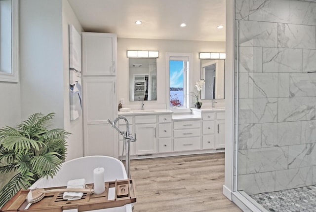 full bath with vanity, wood finished floors, recessed lighting, a freestanding bath, and a shower stall