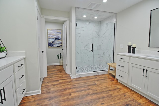 full bath with vanity, wood finished floors, visible vents, a marble finish shower, and recessed lighting