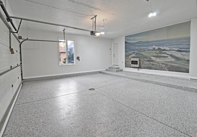 garage featuring heating unit, a garage door opener, and baseboards