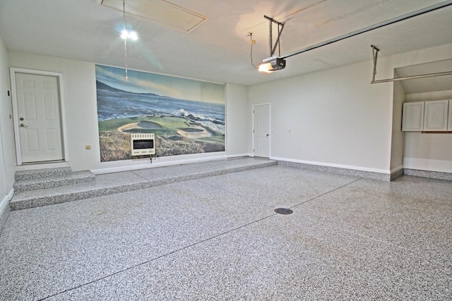 garage featuring heating unit and baseboards