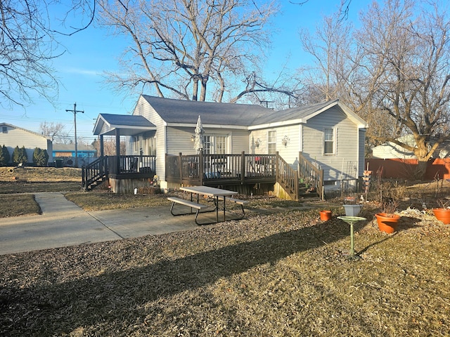 rear view of house featuring a wooden deck and a patio