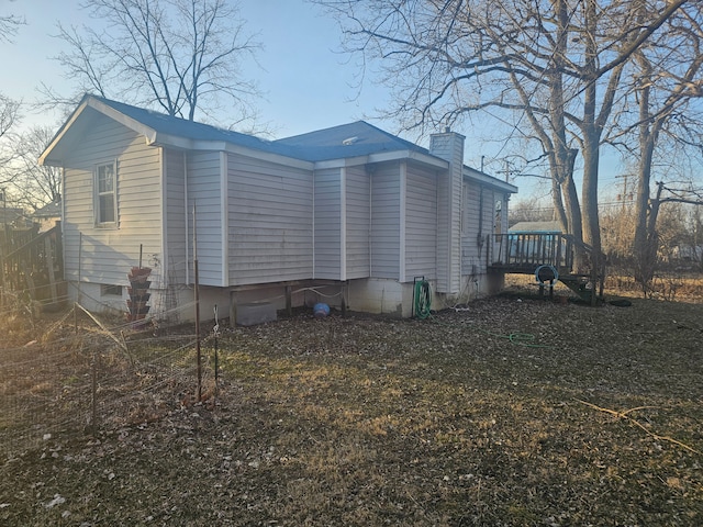 view of property exterior featuring crawl space and a chimney