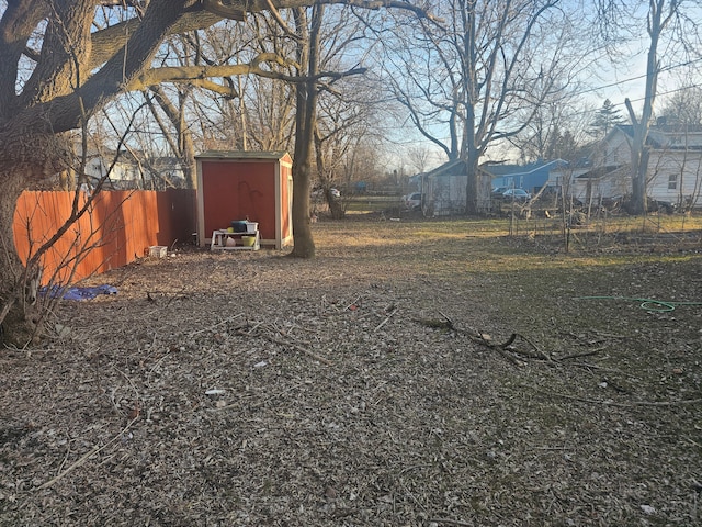 view of yard with a storage unit, an outdoor structure, and fence