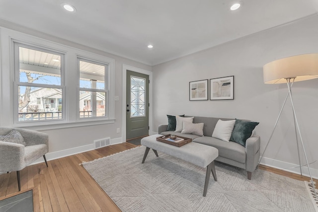 living area with hardwood / wood-style floors, recessed lighting, visible vents, and baseboards