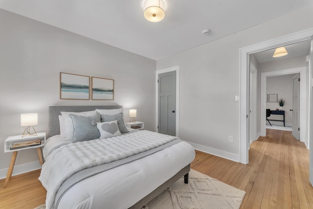 bedroom with baseboards and light wood finished floors