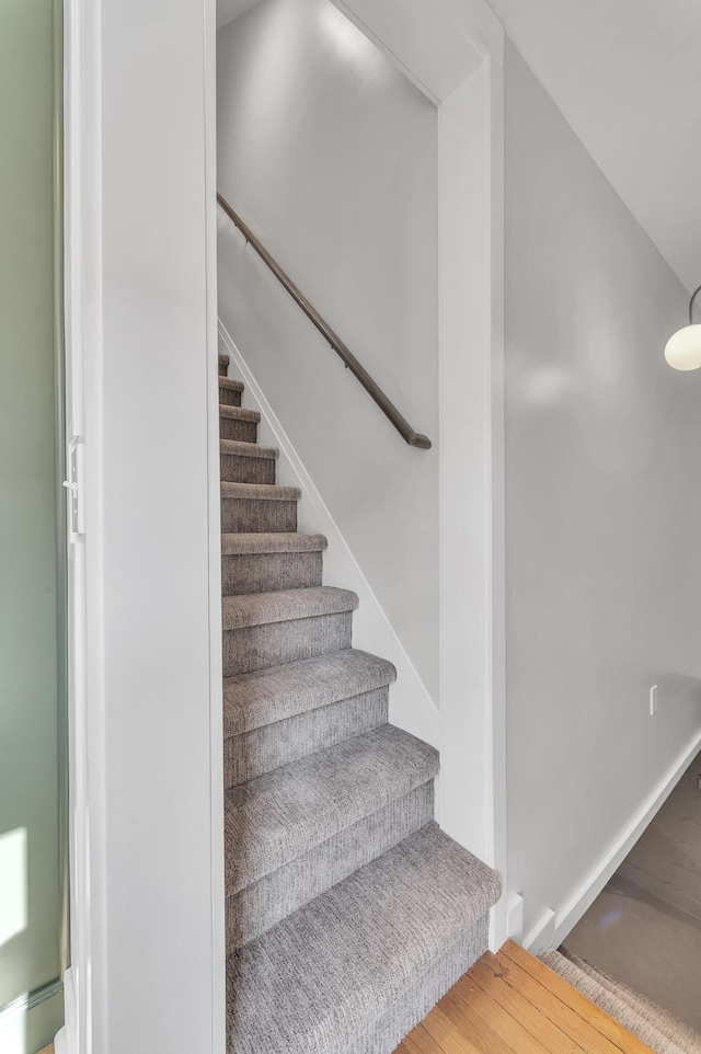 staircase with wood finished floors and baseboards