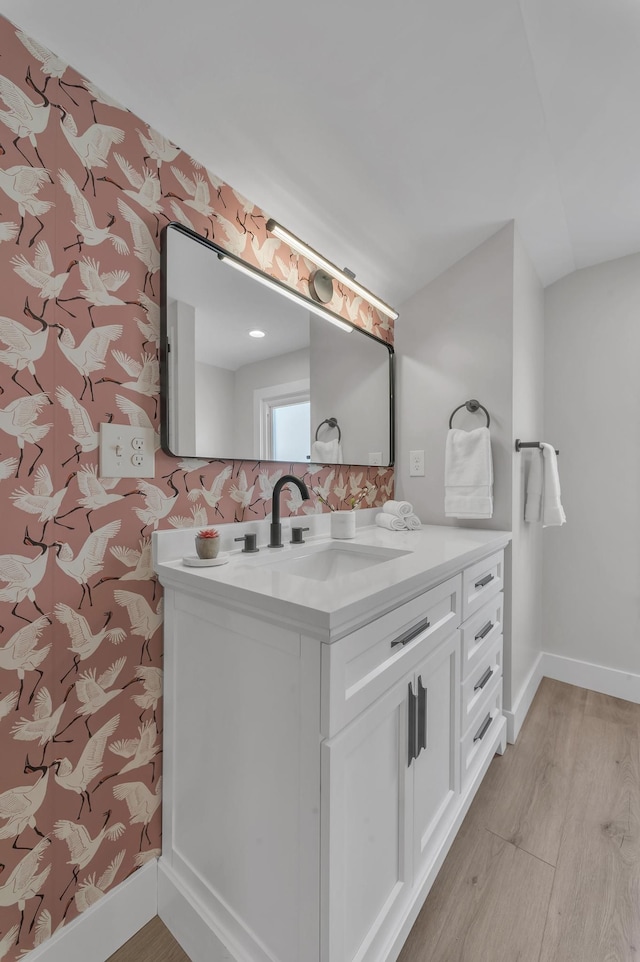 bathroom with baseboards, wood finished floors, and vanity