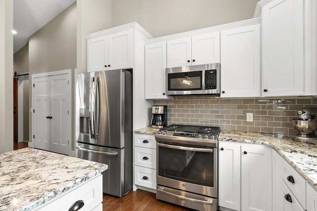 kitchen with white cabinetry, light stone countertops, tasteful backsplash, and appliances with stainless steel finishes