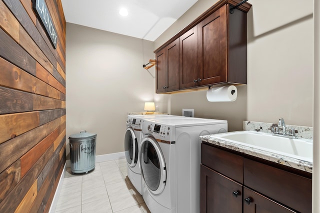 laundry room with independent washer and dryer, a sink, cabinet space, light tile patterned floors, and baseboards