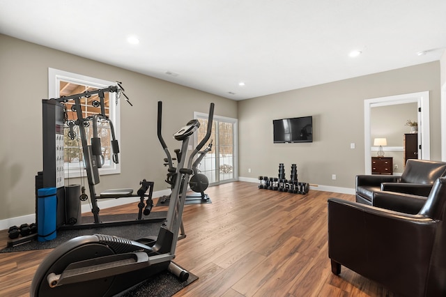 exercise area featuring recessed lighting, wood finished floors, and baseboards