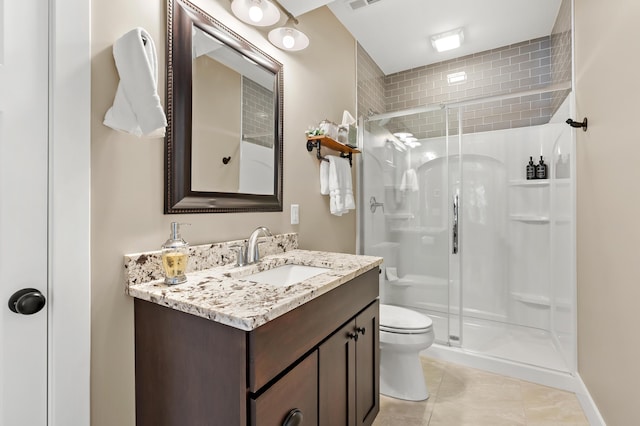 bathroom with vanity, a shower stall, toilet, and tile patterned floors