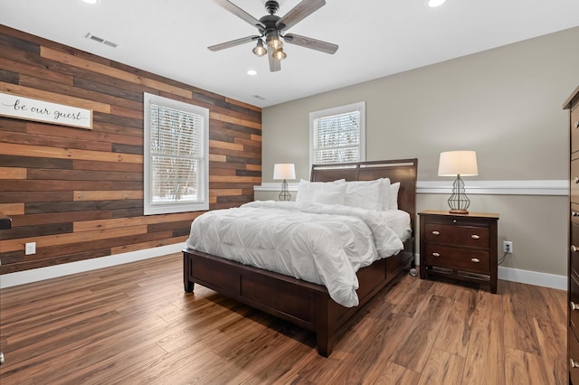 bedroom with visible vents, wooden walls, baseboards, recessed lighting, and wood finished floors