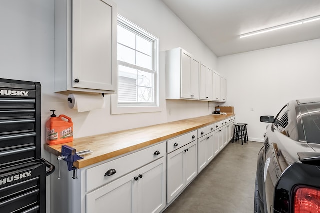 clothes washing area featuring baseboards, cabinet space, and washer and clothes dryer