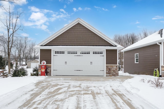 snow covered garage featuring a detached garage