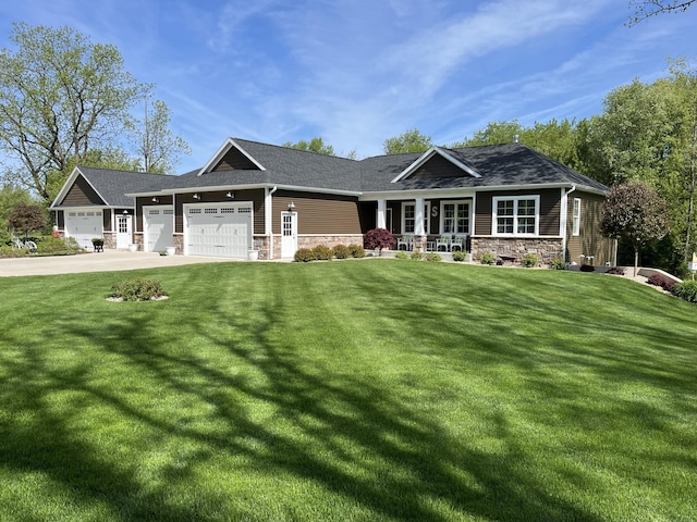 craftsman-style home featuring a front yard, concrete driveway, a garage, and stone siding