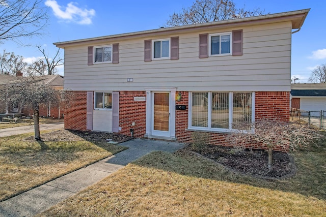 back of property featuring brick siding, a lawn, and fence