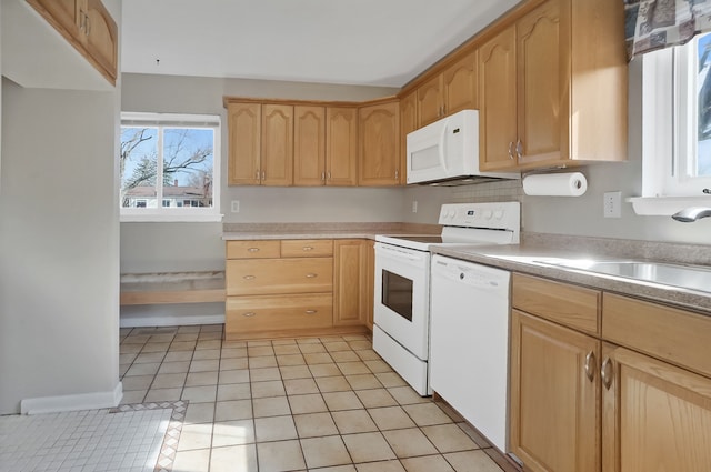 kitchen featuring white appliances, light tile patterned floors, a sink, light brown cabinetry, and light countertops