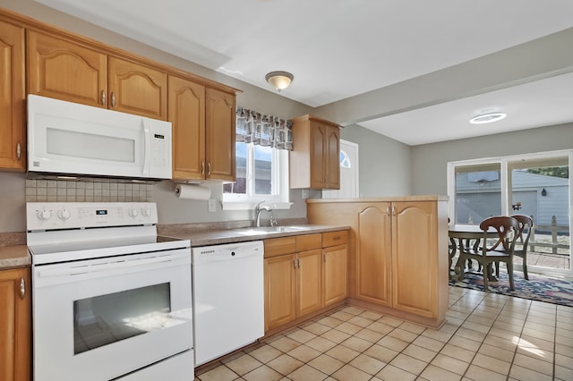 kitchen featuring a sink, white appliances, a peninsula, light tile patterned floors, and decorative backsplash