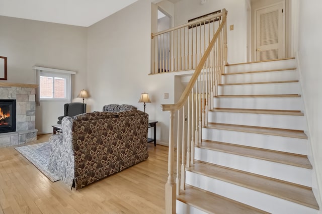 living room with stairway, a fireplace, and wood finished floors