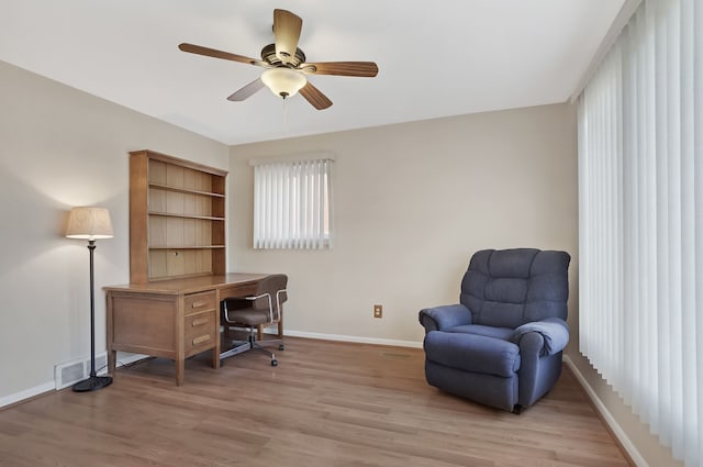 office space featuring light wood-style flooring, visible vents, baseboards, and ceiling fan