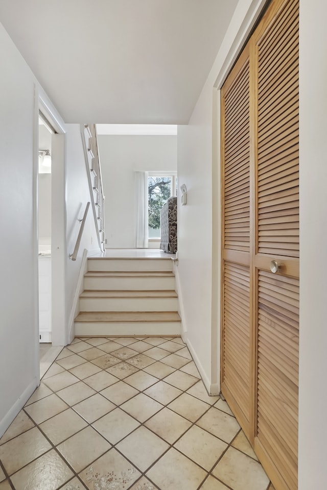 stairway featuring baseboards and tile patterned flooring