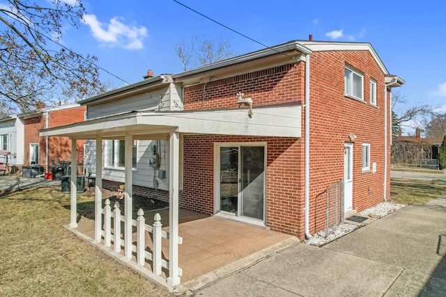 rear view of house featuring a patio area and brick siding