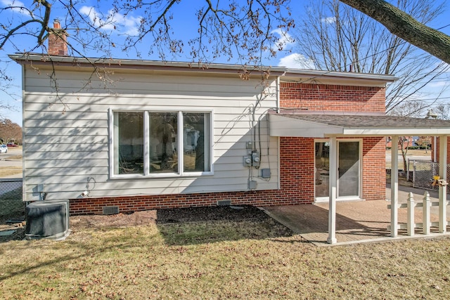 rear view of house featuring crawl space, a lawn, a chimney, and a patio area