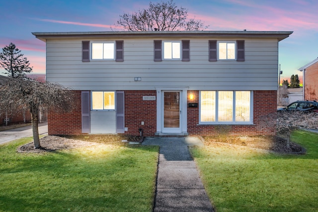 view of front facade with a front yard and brick siding