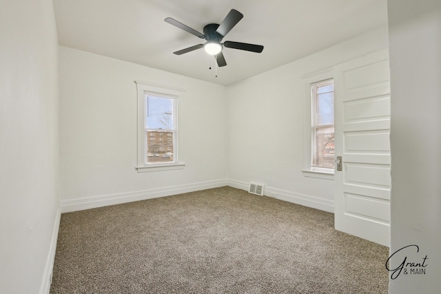 empty room featuring visible vents, baseboards, a healthy amount of sunlight, and carpet flooring