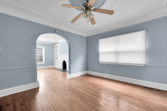 unfurnished living room featuring built in shelves, baseboards, a fireplace with flush hearth, and wood-type flooring