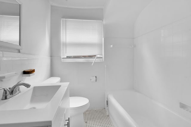 full bath featuring vanity, toilet, and tile walls