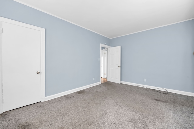 carpeted empty room with baseboards and ornamental molding